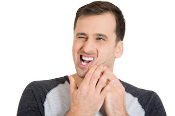 Emergency Dentistry Man in pain holding face